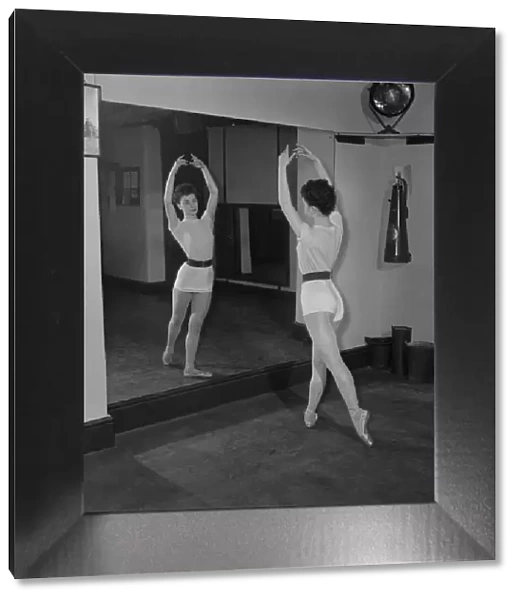 Carole Logan windmill girl doing stretches at the gym. November 1952 C5670-001