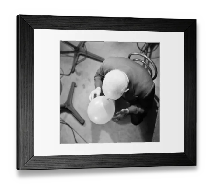 Framed Print : Aerial view of a man blowing up a balloon. November 1952 C5691
