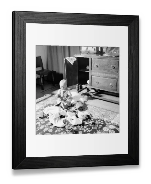 Framed Print : Baby boy looking in the cupboards at his home. October 1952 C5534-002
