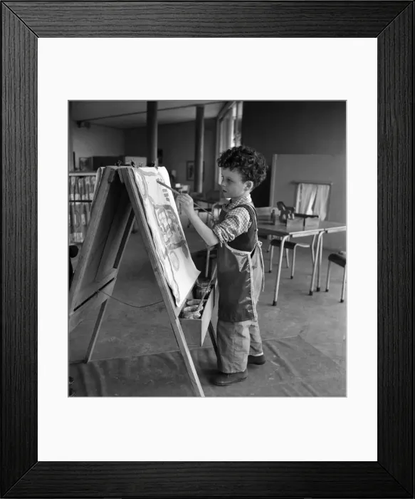 Framed Print : Young boy standing by his easel during an art class at Cookham Nursery School Framed Print : Young boy standing by his easel during an art class at Cookham Nursery School