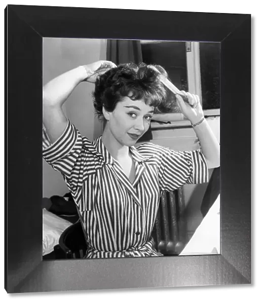 Actress Joan Griffiths fixing her hair in her dressing room before going on stage