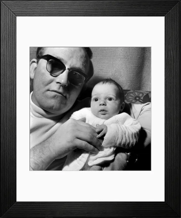 Framed Print : Families: Father holding his newly born baby boy at their home. December 1969 Z12116-001
