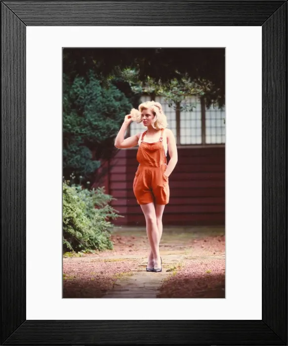 Framed Print : A young model poses in the latest Dungarees and high heels