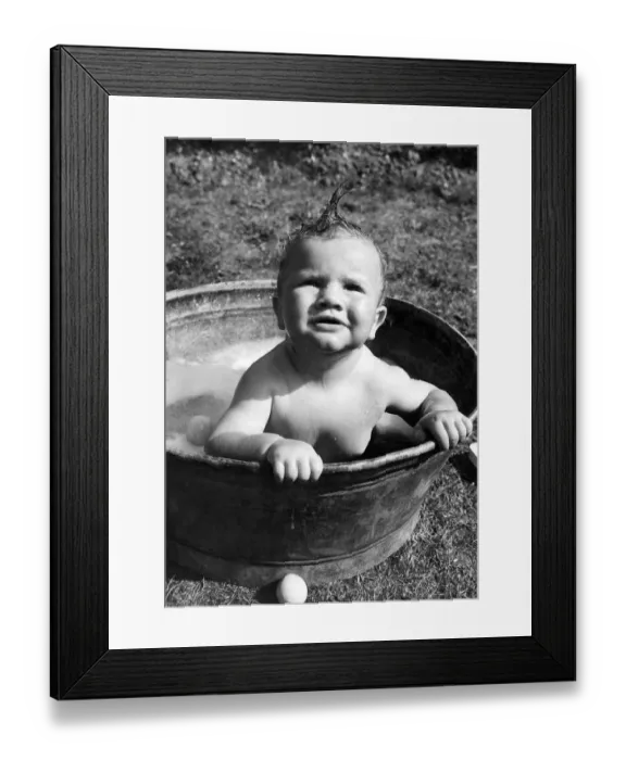 Framed Print : Young toddler having a wash in a tin bath in the back garden in Erith, Kent