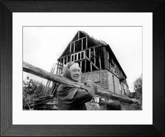 Framed Print : Elderly woman May at work in building her house. July 1978 P009031