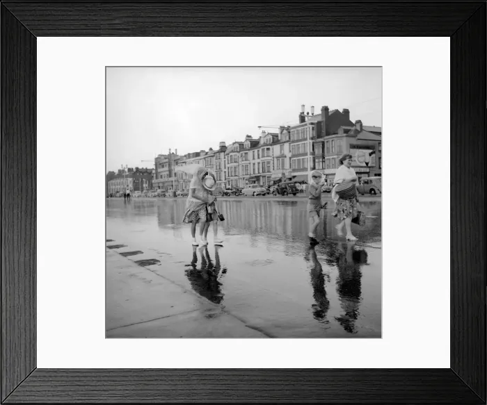 Framed Print : Blackpool after the storm. A couple of young holiday makers make their way off the beach Framed Print : Blackpool after the storm. A couple of young holiday makers make their way off the beach