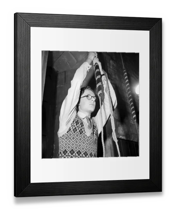 Framed Print : A man pulling a long cord to ring a bell in his church. December 1953 D7601