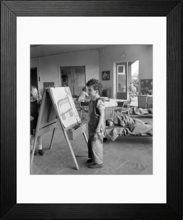Framed Print : Young boy standing by his easel during an art class at Cookham Nursery School Framed Print : Young boy standing by his easel during an art class at Cookham Nursery School