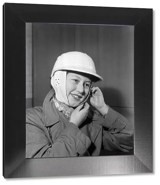Woman strapping on her crash helmet. October 1952 C5018