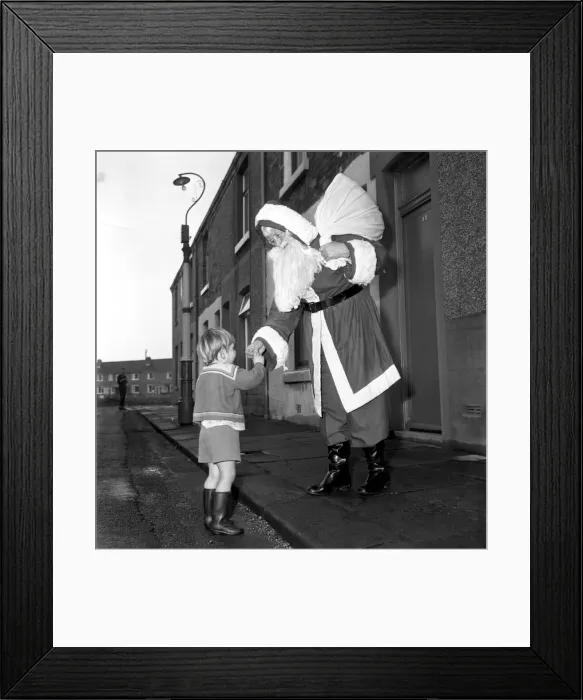 Framed Print : An elderly woman dressed as Santa Claus on her way to an engagement accompanied by Framed Print : An elderly woman dressed as Santa Claus on her way to an engagement accompanied by