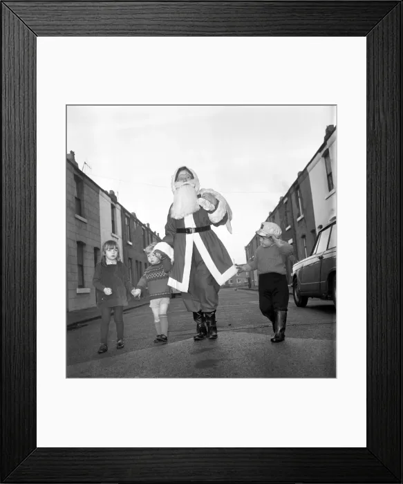 Framed Print : An elderly woman dressed as Santa Claus on her way to an engagement accompanied by