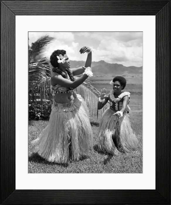 Framed Print : Two girls in grass skirts against a background of palms, flowers and mountains Framed Print : Two girls in grass skirts against a background of palms, flowers and mountains