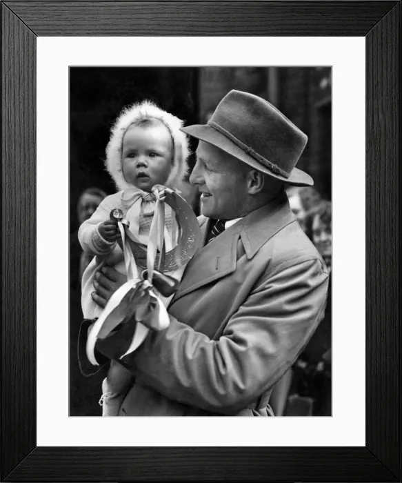 Framed Print : Ces Mountfords baby daughter Carolyn gives her daddy an emblem of Good Luck before Framed Print : Ces Mountfords baby daughter Carolyn gives her daddy an emblem of Good Luck before