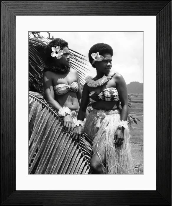 Framed Print : Fiji: Two girls in grass skirts against a background of palms, flowers and mountains Framed Print : Fiji: Two girls in grass skirts against a background of palms, flowers and mountains
