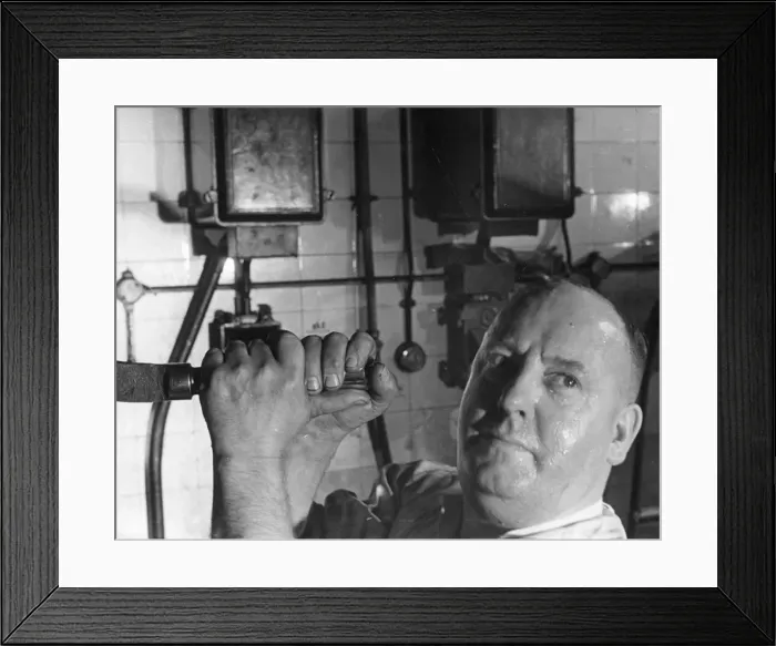 Framed Print : Daily Mirror Newspaper. One of the foundry workers finds the going hot as last nights
