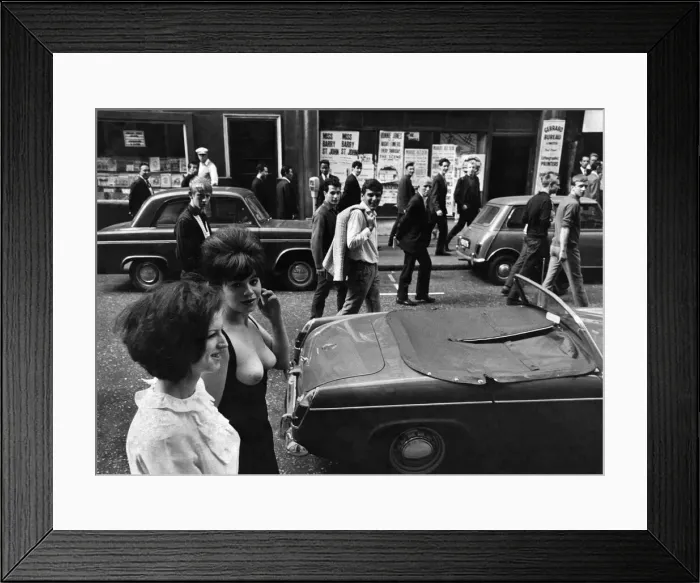 Framed Print : Model Jackie Jorgenser wearing unusual clothing garment showing off her breasts as men
