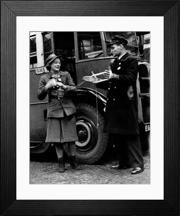 Framed Print : World War II Women. A lady conductor of London Transport makes use of her driver during a Framed Print : World War II Women. A lady conductor of London Transport makes use of her driver during a