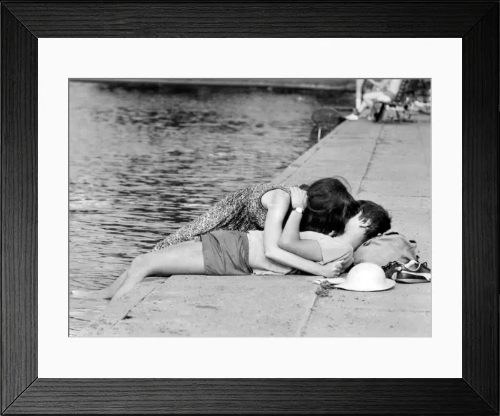 Framed Print : Love and Romance. A young couple oblivious to their surrounding seen here kissing beside Framed Print : Love and Romance. A young couple oblivious to their surrounding seen here kissing beside