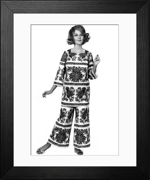 Framed Print : Reveille Fashions. Delia Freeman. modelling trouser suit made of white cotton boldly Framed Print : Reveille Fashions. Delia Freeman. modelling trouser suit made of white cotton boldly