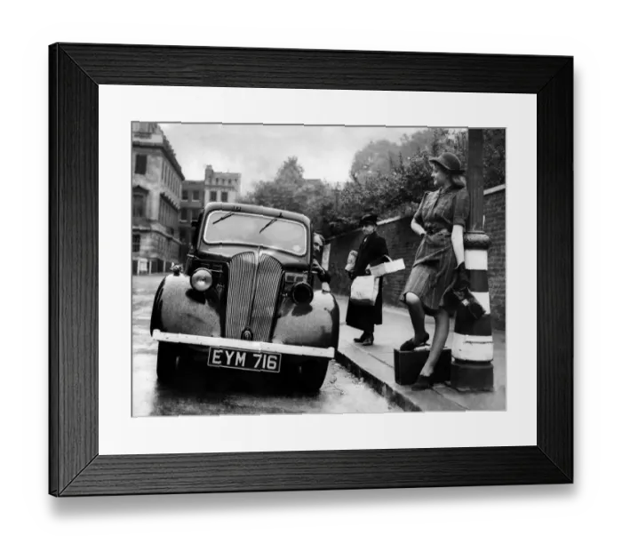 Framed Print : Motorist seen here offer a young woman a lift as he ignores the elderly woman with Framed Print : Motorist seen here offer a young woman a lift as he ignores the elderly woman with