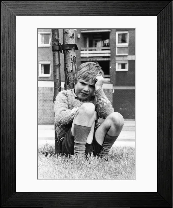 Framed Print : A young boy sits miserable as all his friends aren t outside playing 01  /  06  /  72circa