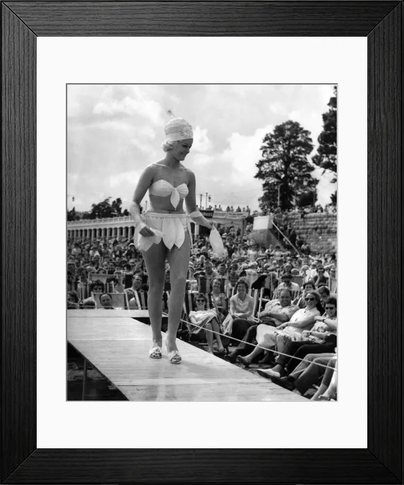 Framed Print : Its all eyes on model Susan Bell, as she peels the petals from her yellow poplin