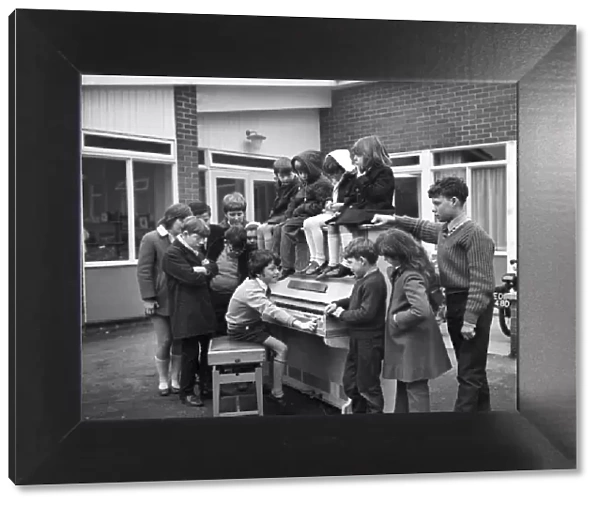 Eleven year old Martin Hawes entertains his school friends to a tune on the John Lennon