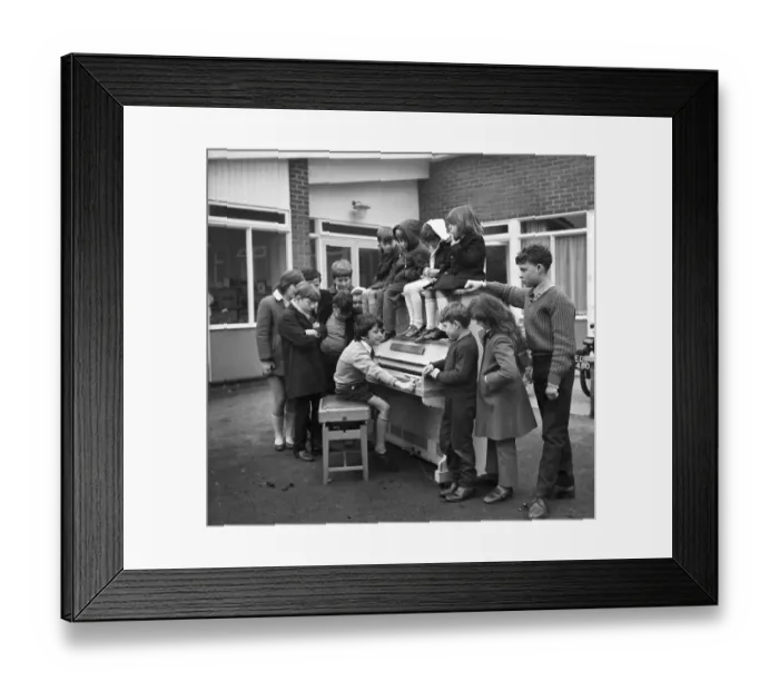 Framed Print : Eleven year old Martin Hawes entertains his school friends to a tune on the John Lennon Framed Print : Eleven year old Martin Hawes entertains his school friends to a tune on the John Lennon