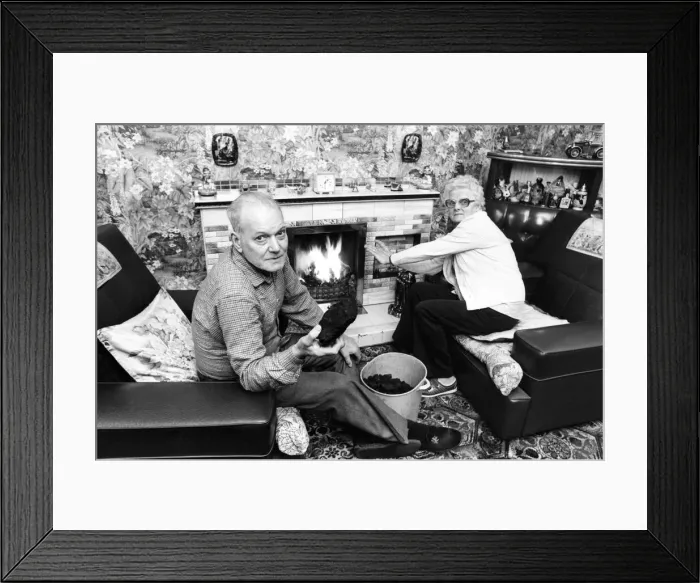 Framed Print : Ex-Pitman Charlie Wilson and his wife Margaret beside their coal fire with the free coal