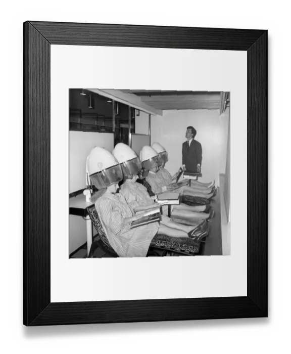 Framed Print : Women reading magazines at the John London Hair and Beauty Saloon whilst under the driers