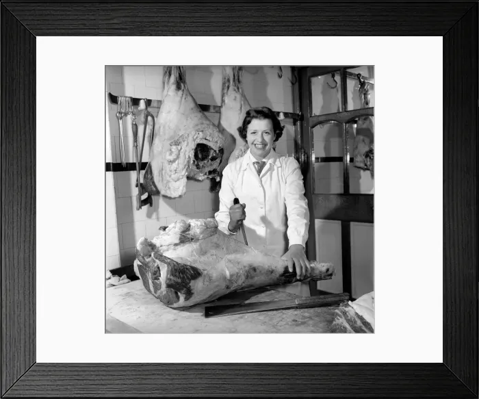Framed Print : Woman butcher seen here at work. 1954
