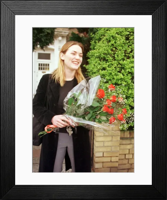 Framed Print : Kate Winslet holding bouquet of flowers outside her home as she told of her love for film