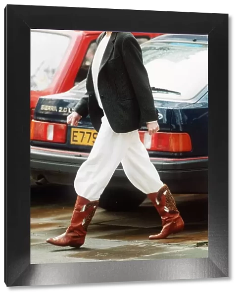 Princess Diana wearing an unusual combination of white trousers, boots