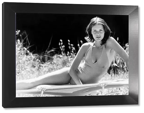 Sylvia Kristel in a swimsuit on a folding bed, on her side