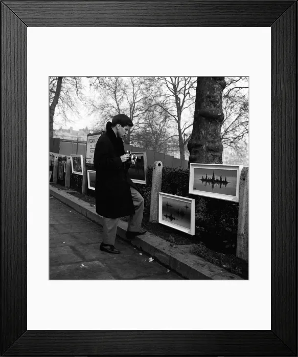 Framed Print : Frank Sinatra Junior in London January 1964 looking at painting displayed on fence
