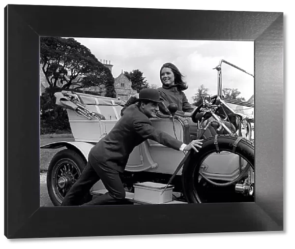Patrick Macnee & Diana Rigg stars of The Avengers pushing a vintage car on set