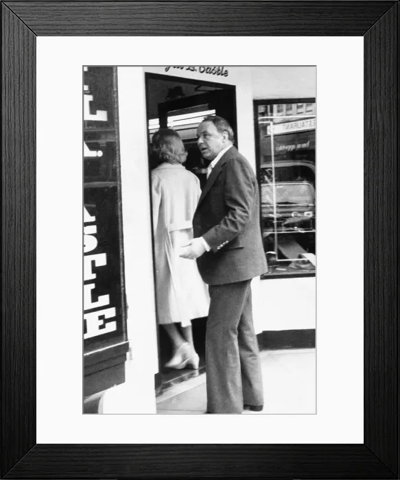 Framed Print : Frank Sinatra following barbara marx into a shop Framed Print : Frank Sinatra following barbara marx into a shop