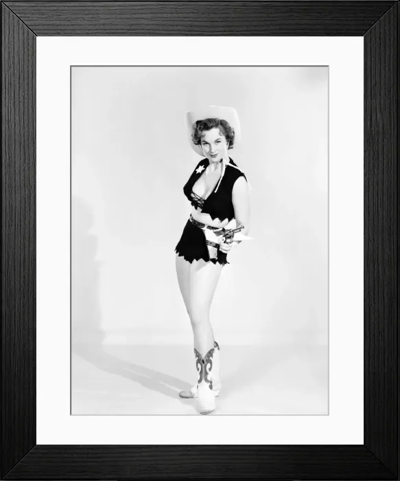 Framed Print : Model dressed as cow girl posing with pistol. Circa 1957 Framed Print : Model dressed as cow girl posing with pistol. Circa 1957