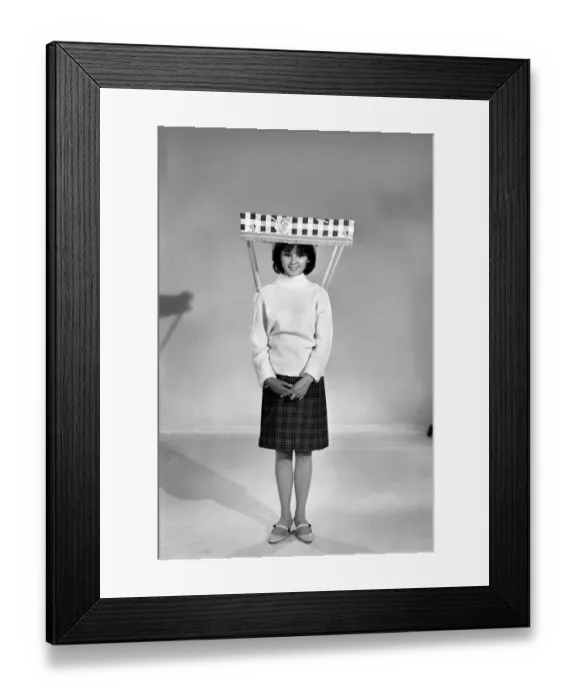 Framed Print : Therese Howard Jones demonstrating the wear-me umbrella. Model. Circa 1959