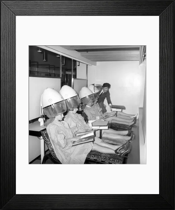 Framed Print : Women reading magazines at the John London Hair and Beauty Saloon whilst under the driers Framed Print : Women reading magazines at the John London Hair and Beauty Saloon whilst under the driers
