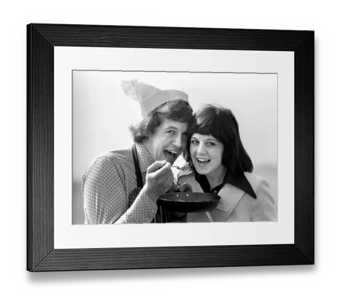 Framed Print : Britains top man in the kitchen sharing his food with a woman, eating from the pan