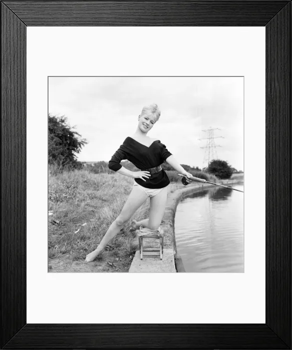 Framed Print : Clothing: Fashion: Beachwear: Model by the river bank fishing. August 1963 E490-004
