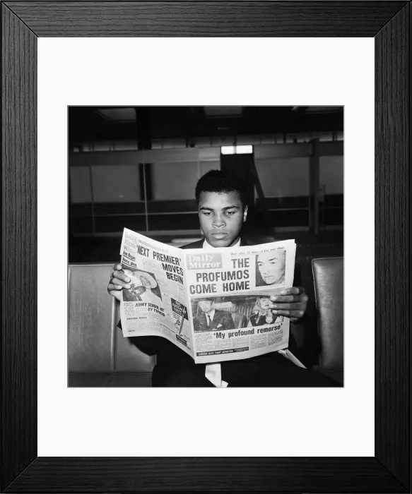 Framed Print : Cassius Clay reading the Daily Mirror, after his World Title Fight win against Henry Framed Print : Cassius Clay reading the Daily Mirror, after his World Title Fight win against Henry