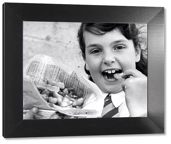 A young girl enjoying fish and chips the old fashioned way from a newspaper in 1977
