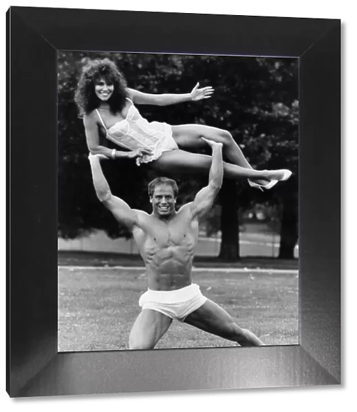 Model Linda Lusardi being lifted by nearly naked muscley strong man Julien Moss in