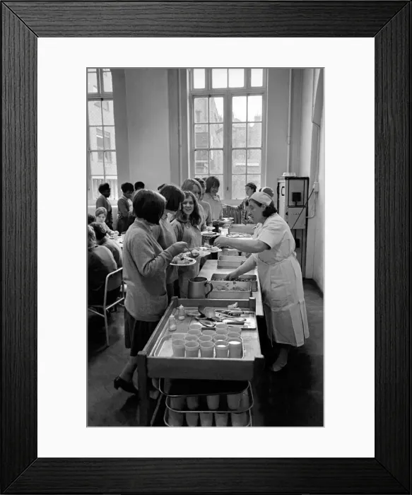 Framed Print : School Dinners. General scenes of school dinner. Ladies serving meal to pupils in