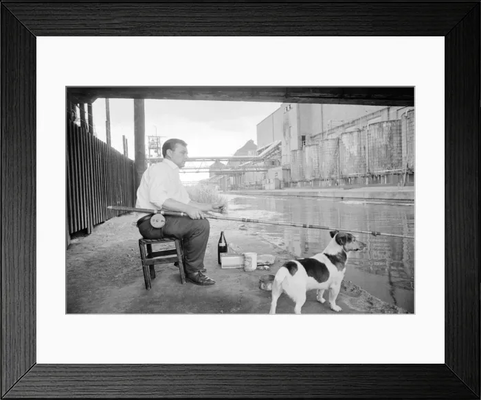 Framed Print : This man enjoys a smoke as he wait patiently for a bite Framed Print : This man enjoys a smoke as he wait patiently for a bite