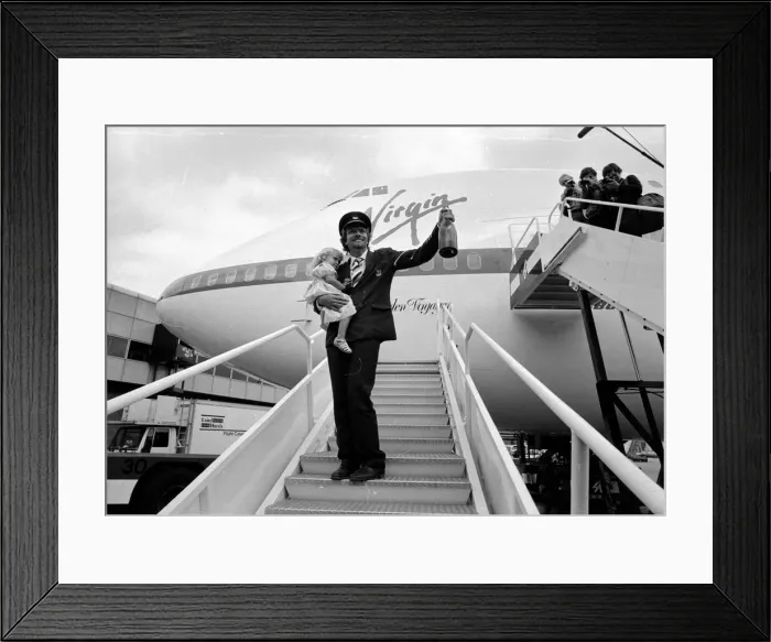 Framed Print : Richard Branson holding a bottle of champagne and his daughter on the steps of Framed Print : Richard Branson holding a bottle of champagne and his daughter on the steps of
