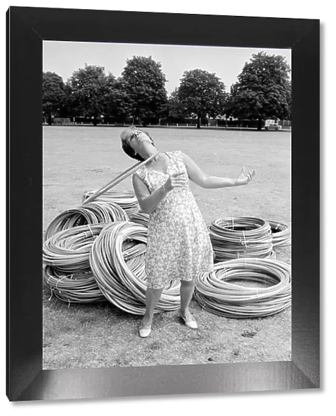 Pensioner playing with Hula Hoops in a Twickenham park. August 1976 P76 734
