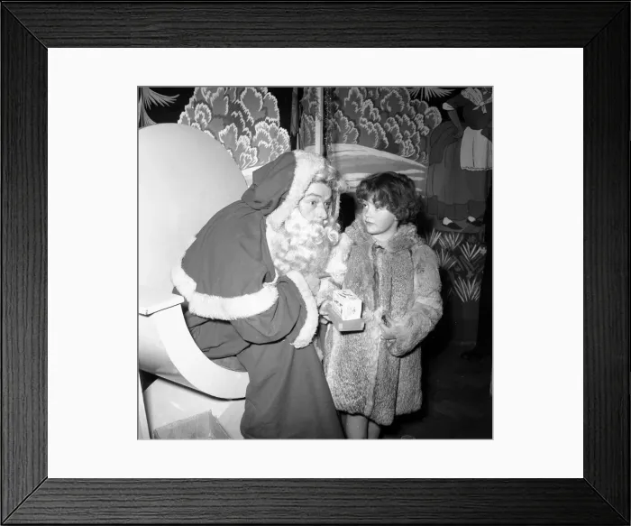 Framed Print : Father Christmas Harry Proctor seen here giving a gift to a small girl at the daily